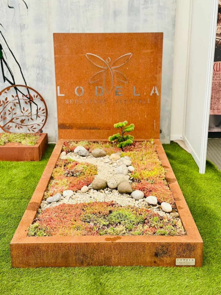 Tombe végétale Lodela en acier corten recouverte de plantes, pour un cimetière naturel.